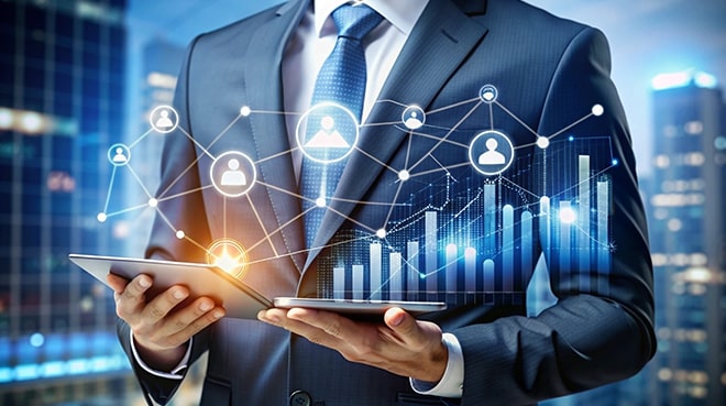 A businessman in a suit uses a tablet with digital graphs and network icons overlayed, symbolizing data analytics and digital connectivity.